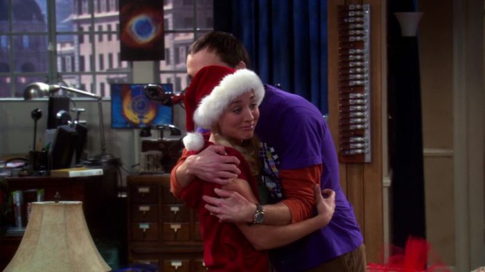 Sheldon Cooper hugging Penny after receiving a signed DNA napkin in The Big Bang Theory Christmas episode.