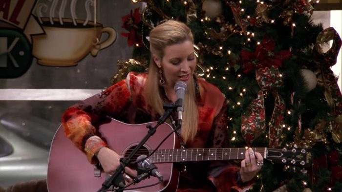 Phoebe Buffay performing her iconic Christmas song on guitar.